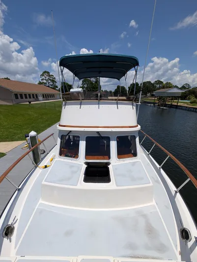 Monarch Yacht Photos Pics 1997 Monk 36 boat docked by a canal under a clear blue sky.