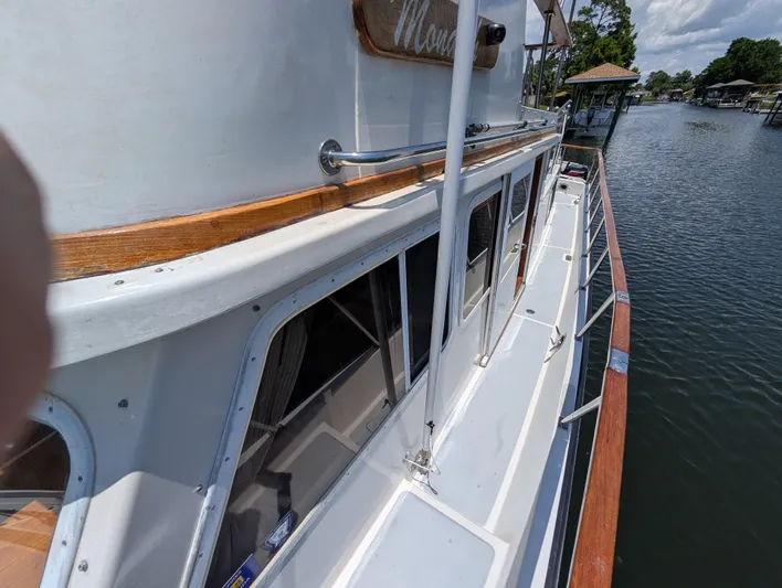 Monarch Yacht Photos Pics Side view of a 1997 Monk 36 boat docked by a calm waterfront.