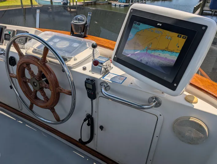 Monarch Yacht Photos Pics Helm of 1997 Monk 36 boat with wooden wheel and navigation display.