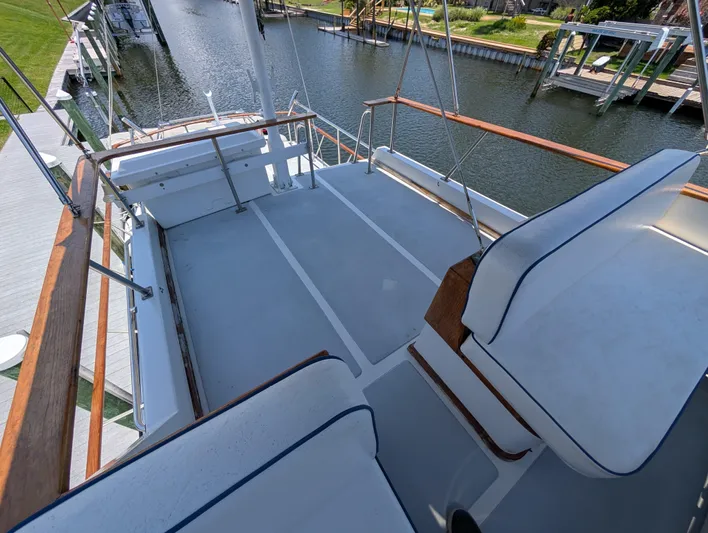 Monarch Yacht Photos Pics 1997 Monk 36 boat deck with seating, docked by a calm waterfront.