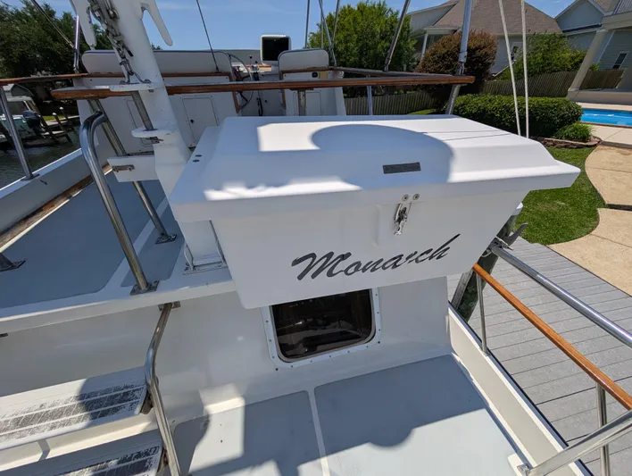 Monarch Yacht Photos Pics 1997 Monk 36 boat deck with "Monarch" name, featuring wooden railings and outdoor seating.