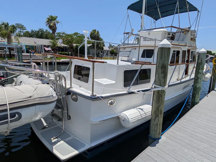 Monarch Yacht Photos Pics 1997 Monk 36 yacht docked at marina with inflatable boat and blue canopy.