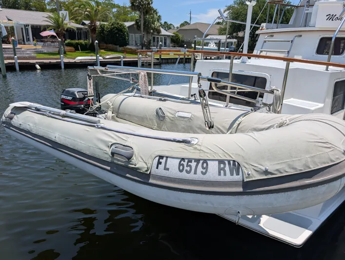 Monarch Yacht Photos Pics Inflatable dinghy attached to a 1997 Monk 36 boat, docked in a marina.