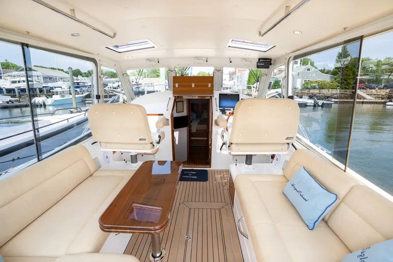 Eagle Wing Yacht Photos Pics Interior of 2017 MJM 40z Downeast yacht with beige seating and wooden table.