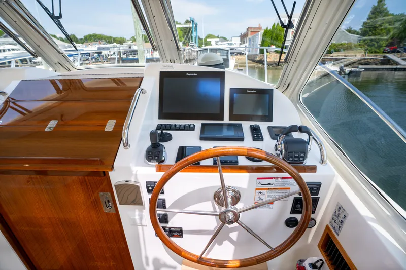 Eagle Wing Yacht Photos Pics Helm of 2017 MJM 40z Downeast boat with navigation screens and wooden steering wheel.