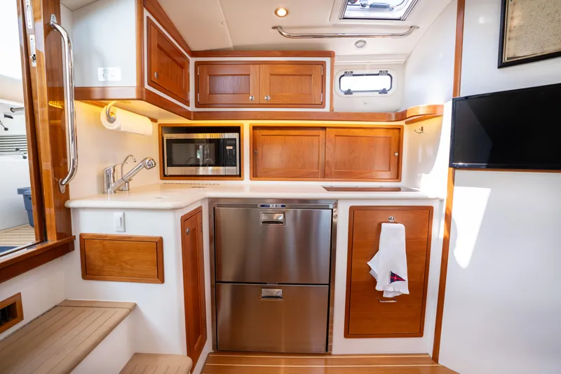 Eagle Wing Yacht Photos Pics 2017 MJM 40z Downeast yacht kitchen with wood cabinets, stainless appliances, and modern fixtures.