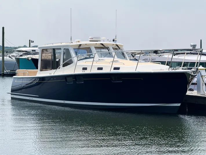 Eagle Wing Yacht Photos Pics 2017 MJM 40z Downeast yacht docked in marina, sleek design, calm water reflection.