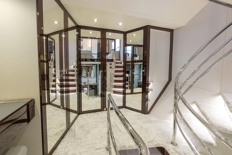 Reunion Yacht Photos Pics Luxurious interior of 2019 Sunseeker 95 Yacht with elegant staircase and mirrored walls.