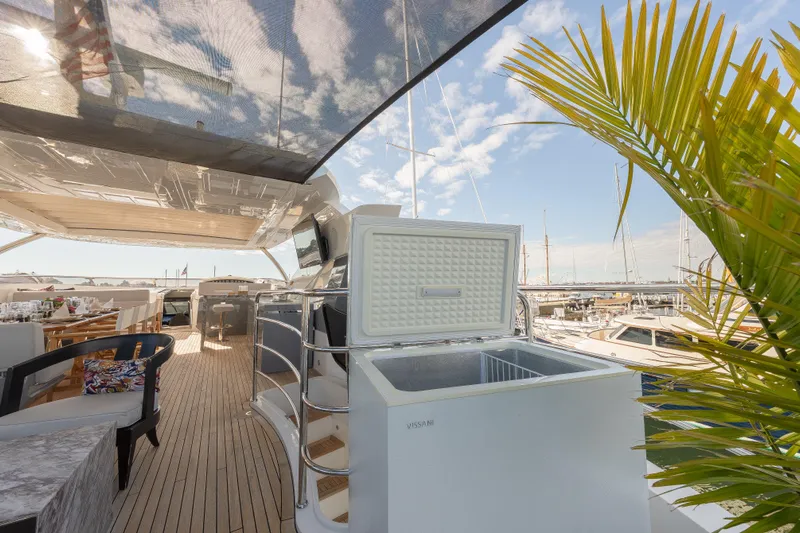 Reunion Yacht Photos Pics Luxurious Sunseeker 95 Yacht 2019 deck with open cooler, dining area, and marina view.