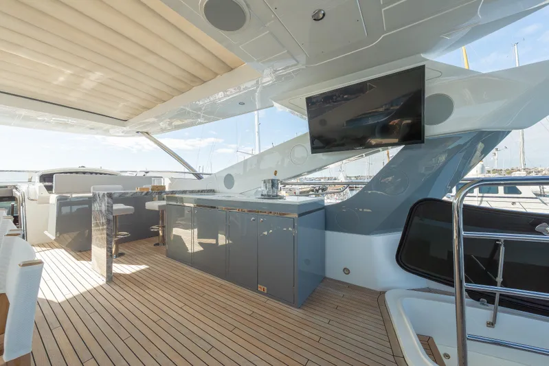 Reunion Yacht Photos Pics Luxurious 2019 Sunseeker 95 Yacht deck with modern bar and TV, featuring sleek design.