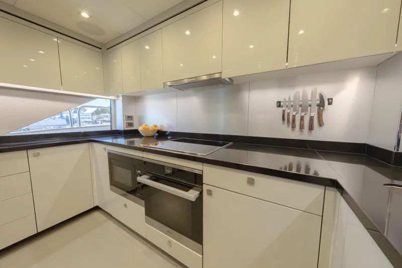 Reunion Yacht Photos Pics Luxurious kitchen interior of 2019 Sunseeker 95 Yacht with modern appliances and sleek design.