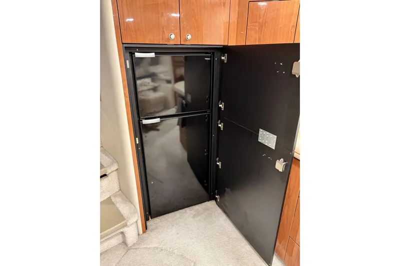  Yacht Photos Pics Open refrigerator inside 1999 Sea Ray Sundancer 460 yacht, with wooden cabinetry and carpeted flooring.