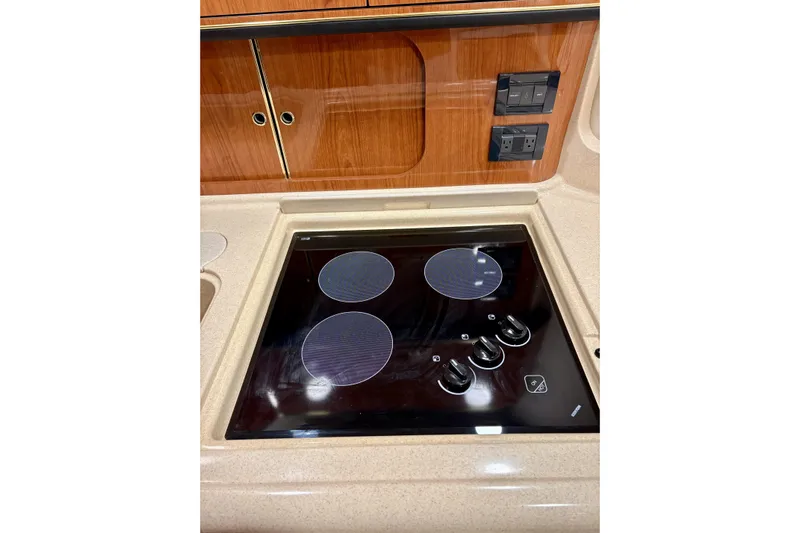  Yacht Photos Pics 1999 Sea Ray Sundancer 460 yacht kitchen with electric stovetop and wooden cabinetry.