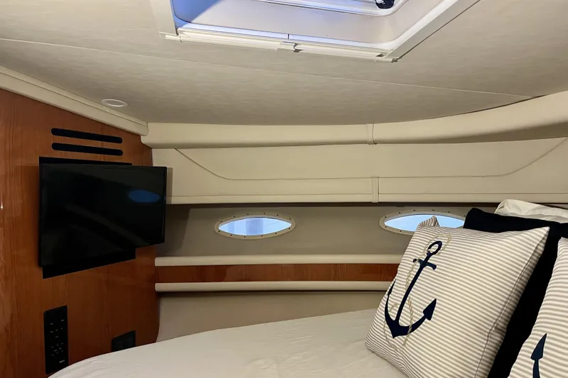  Yacht Photos Pics Interior cabin of 1999 Sea Ray Sundancer 460 with TV and nautical-themed pillows.