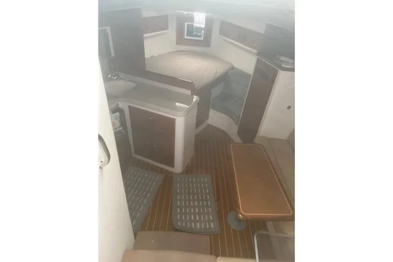 Miss Madison Yacht Photos Pics 2003 Cabo 35 Express cabin interior with bed, table, and kitchenette.