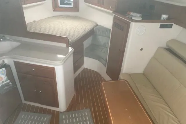 Miss Madison Yacht Photos Pics 2003 Cabo 35 Express cabin interior with bed, seating, and kitchenette.