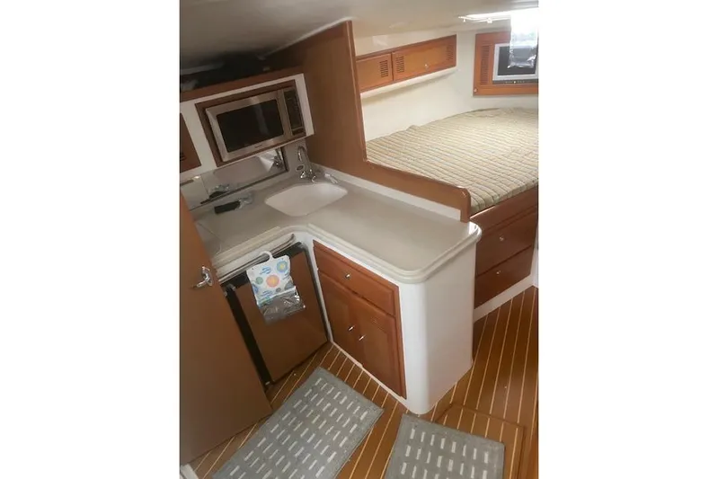 Miss Madison Yacht Photos Pics 2003 Cabo 35 Express interior with kitchenette, sink, and bed.