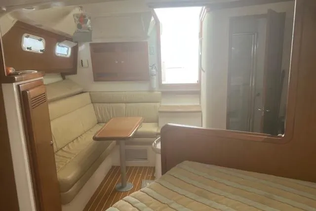 Miss Madison Yacht Photos Pics 2003 Cabo 35 Express cabin interior with seating, table, and bed.