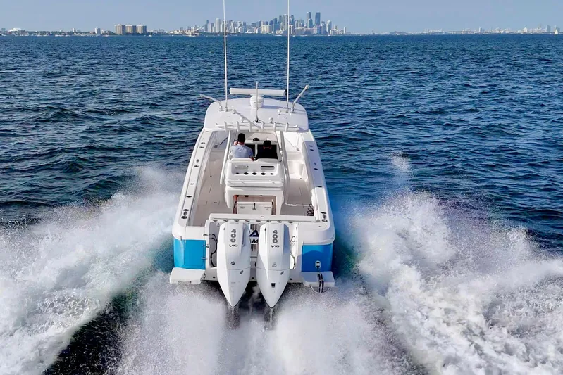 V10 400's Yacht Photos Pics 2015 Intrepid 375 Center Console boat cruising on open water with city skyline in background.