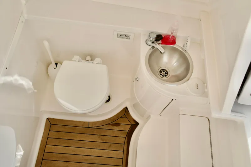 V10 400's Yacht Photos Pics 2015 Intrepid 375 Center Console boat bathroom with toilet, sink, and wooden floor.