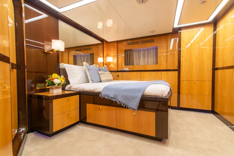 Intrigue Yacht Photos Pics Luxurious bedroom interior of 2010 Jade 95 Motor Yacht with elegant wood paneling.