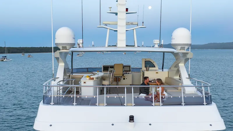 Intrigue Yacht Photos Pics Jade 95 Motor Yacht 2010 on serene water with couple enjoying the deck.