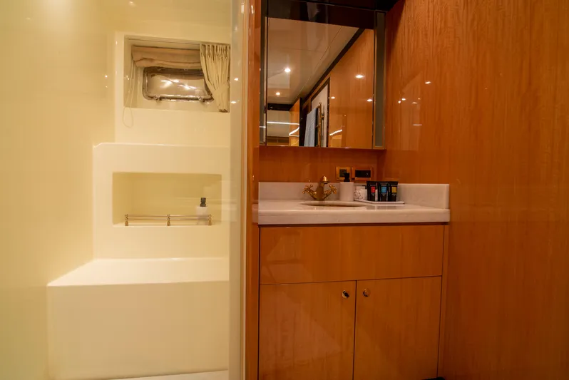 Intrigue Yacht Photos Pics Luxurious bathroom interior of 2010 Jade 95 Motor Yacht with wooden cabinetry and modern fixtures.