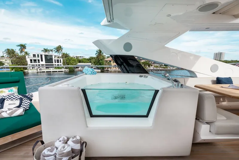 Mirracle Yacht Photos Pics Luxurious 2018 Sunseeker 95 Yacht with jacuzzi on deck, overlooking waterfront homes.