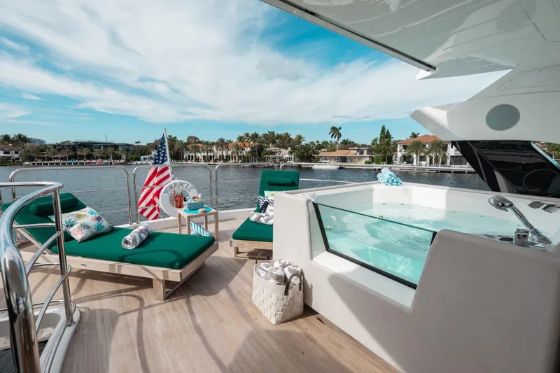 Mirracle Yacht Photos Pics Luxurious 2018 Sunseeker 95 Yacht deck with jacuzzi, sun loungers, and scenic waterfront view.