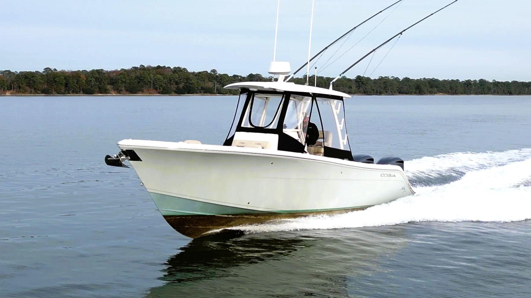 2016 Cobia 296 Center Console boat cruising on calm water.
