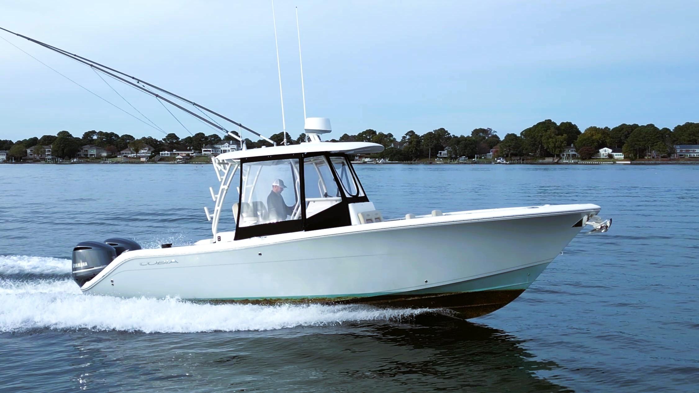 2016 Cobia 296 Center Console boat cruising on calm water.