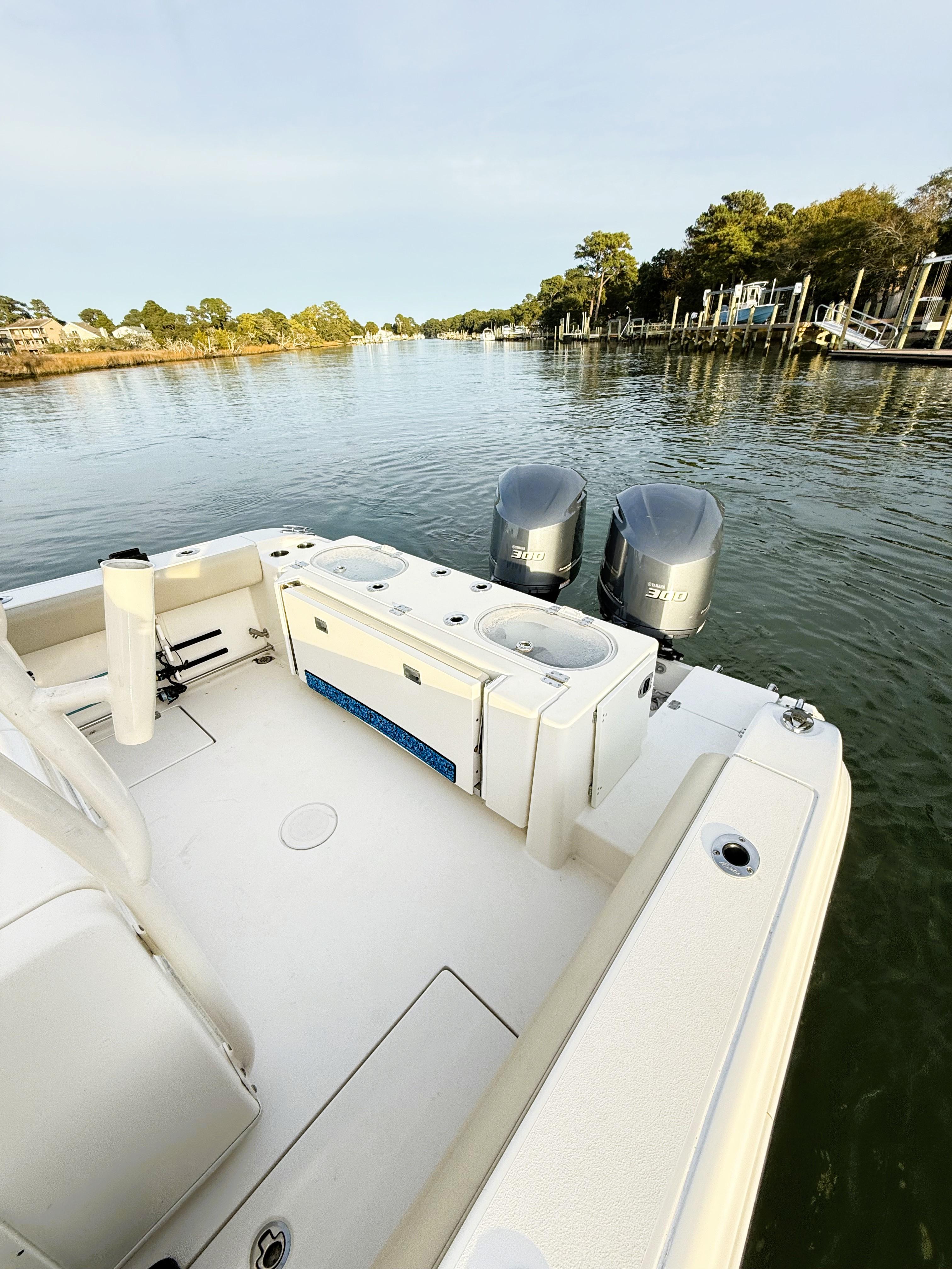 2016 Cobia 296 Center Console boat with dual engines on a calm river.