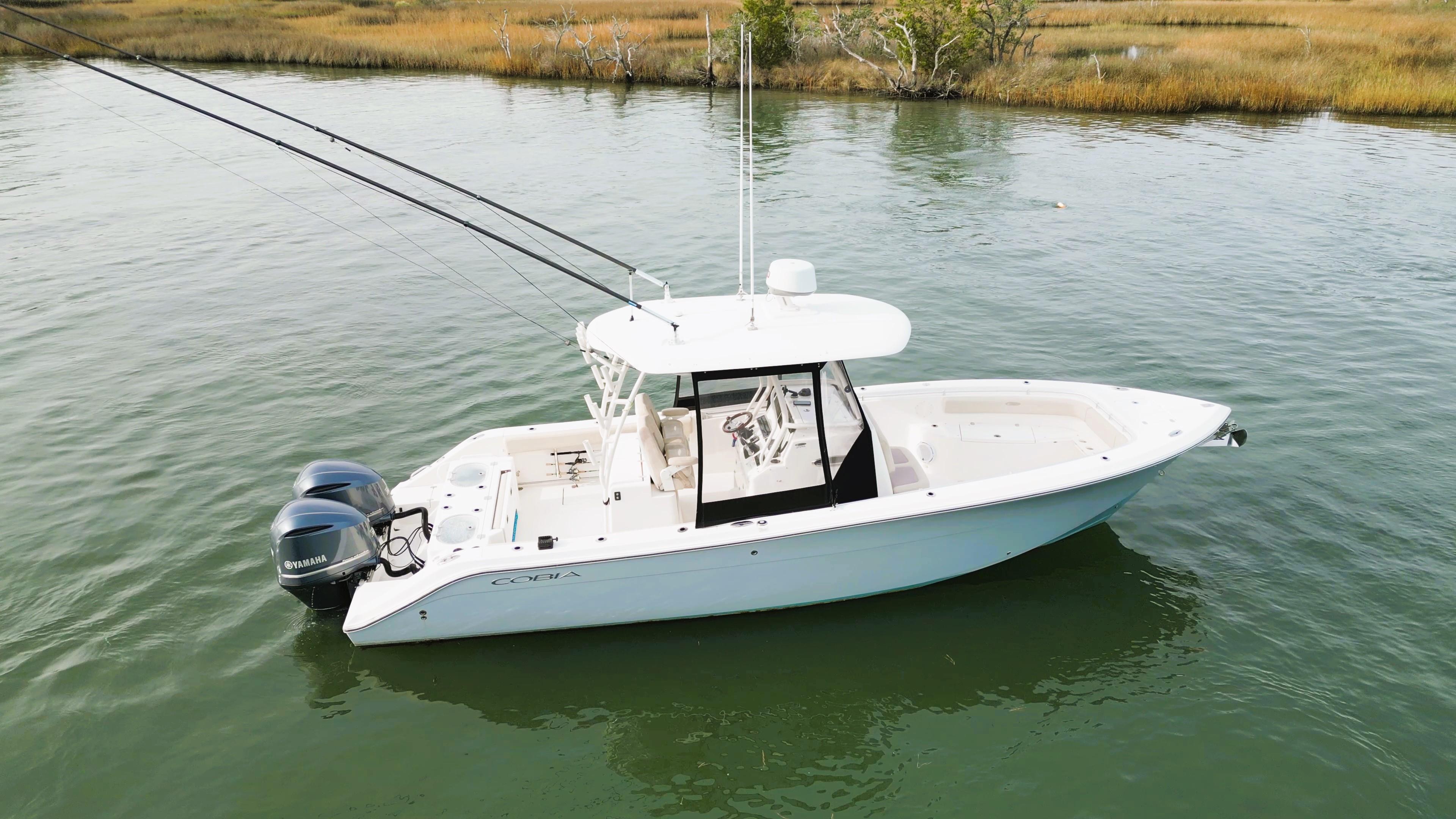 2016 Cobia 296 Center Console boat on calm water with dual engines.