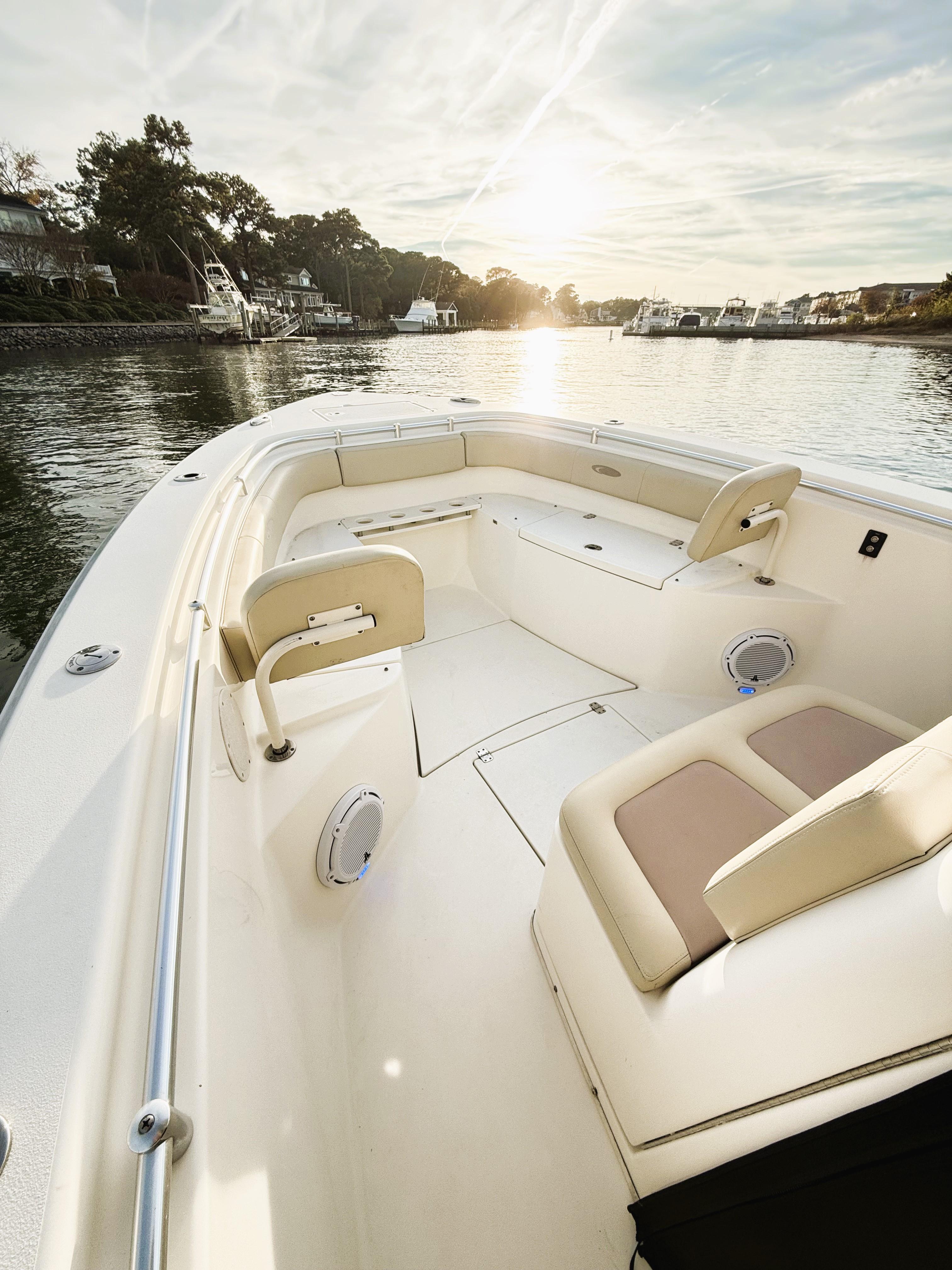 2016 Cobia 296 Center Console boat on serene water at sunset.