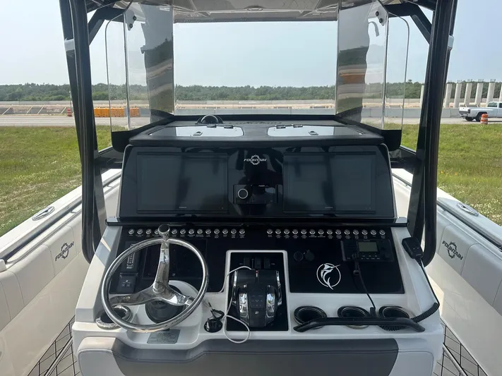  Yacht Photos Pics 2021 Fountain 34TE boat dashboard with steering wheel and control panels.