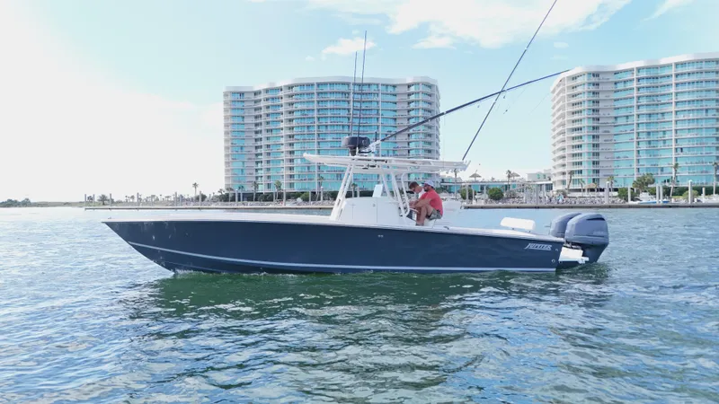 Extremely Clean / Fish Ready Yacht Photos Pics 2004 Jupiter 31 FS boat on water with modern buildings in the background.