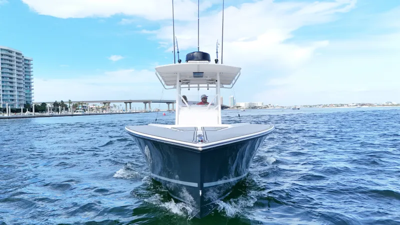 Extremely Clean / Fish Ready Yacht Photos Pics 2004 Jupiter 31 FS boat cruising on open water with cityscape background.