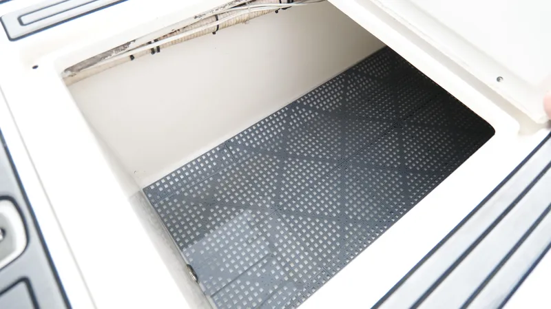 Extremely Clean / Fish Ready Yacht Photos Pics Open storage compartment on a 2004 Jupiter 31 FS boat, featuring a non-slip mat.