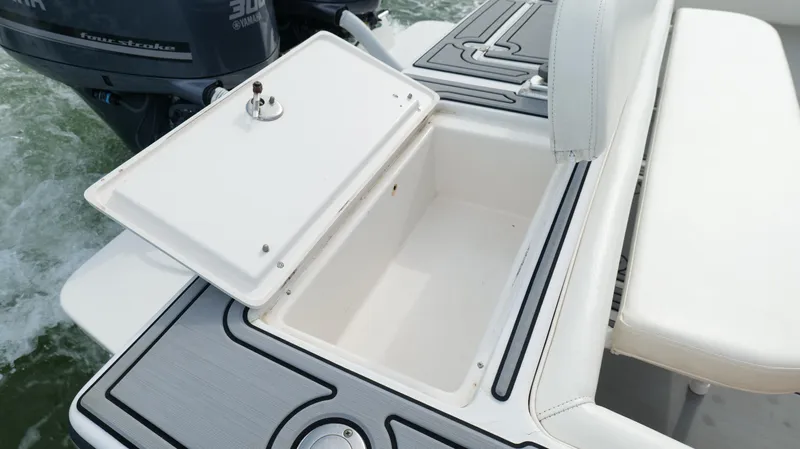 Extremely Clean / Fish Ready Yacht Photos Pics Open storage compartment on a 2004 Jupiter 31 FS boat, with visible water in the background.