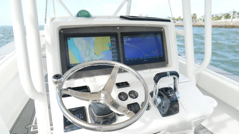 Extremely Clean / Fish Ready Yacht Photos Pics Center console of a 2004 Jupiter 31 FS boat with navigation screens and steering wheel.