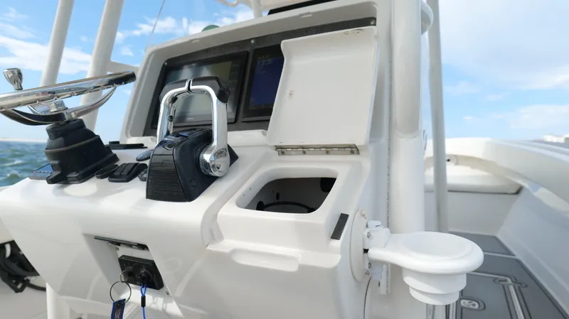 Extremely Clean / Fish Ready Yacht Photos Pics Control panel of a 2004 Jupiter 31 FS boat with open compartments and navigational equipment.