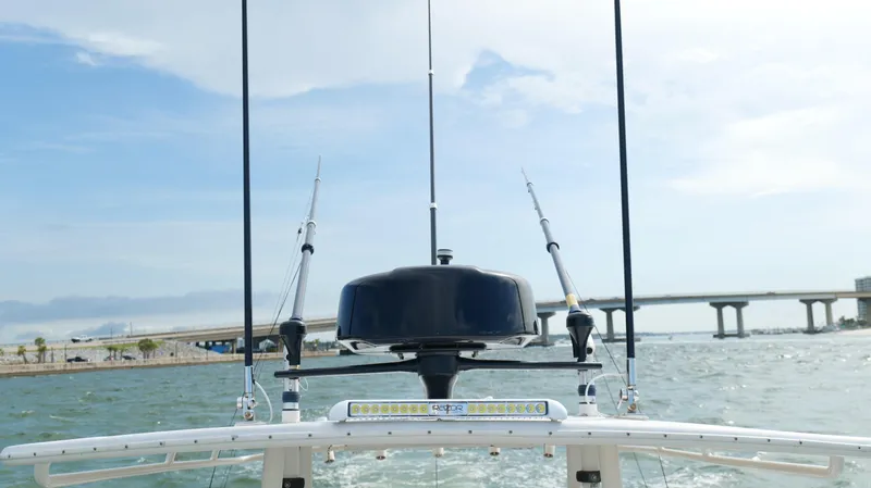 Extremely Clean / Fish Ready Yacht Photos Pics 2004 Jupiter 31 FS boat with fishing rods and radar, cruising near a bridge on a sunny day.