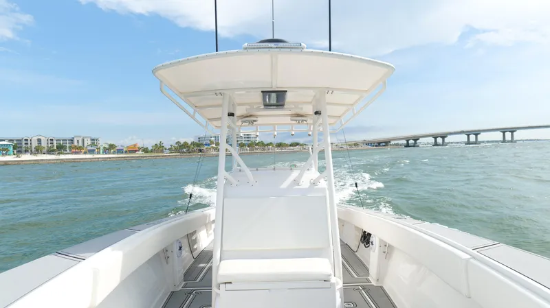 Extremely Clean / Fish Ready Yacht Photos Pics 2004 Jupiter 31 FS boat cruising on open water near a bridge and coastline.