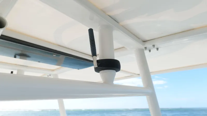 Extremely Clean / Fish Ready Yacht Photos Pics Close-up of a 2004 Jupiter 31 FS boat's T-top structure against a clear sky and ocean backdrop.