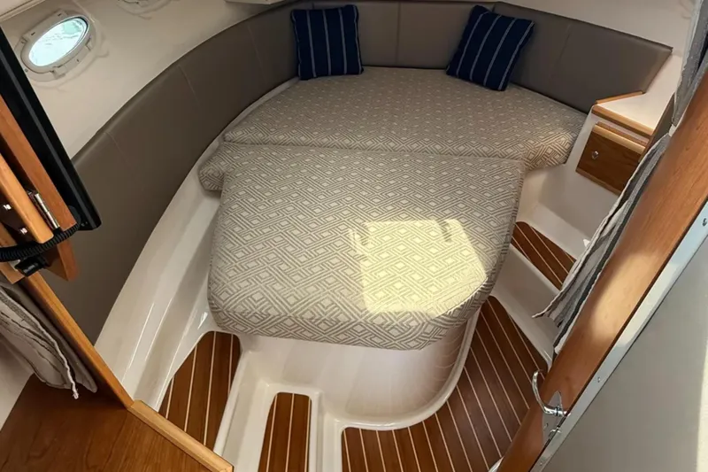  Yacht Photos Pics 2021 Cutwater C-32 Coupe cabin interior with patterned bedding and wooden flooring.