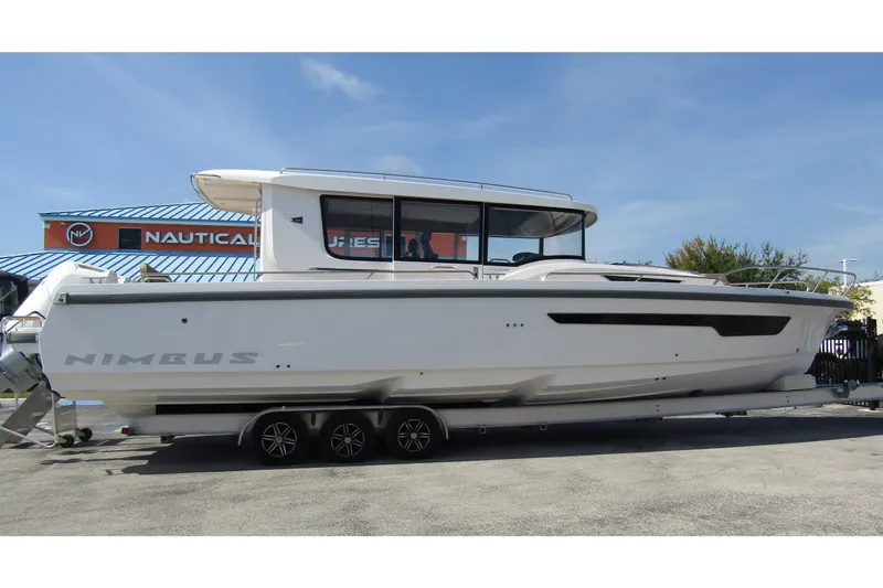 Yacht Photos Pics 2025 Nimbus Commuter 11 boat on trailer, parked outdoors under clear sky.