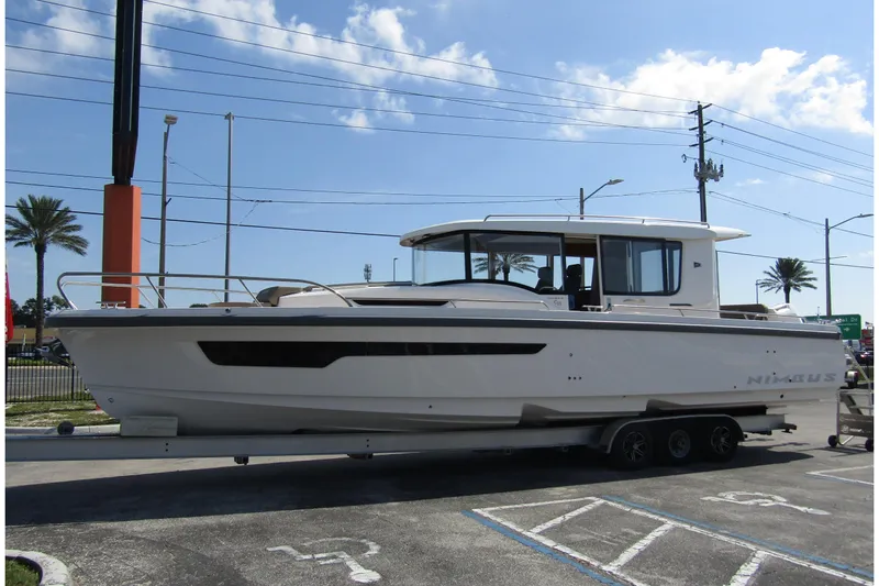  Yacht Photos Pics 2025 Nimbus Commuter 11 boat on trailer, parked outdoors under clear sky.