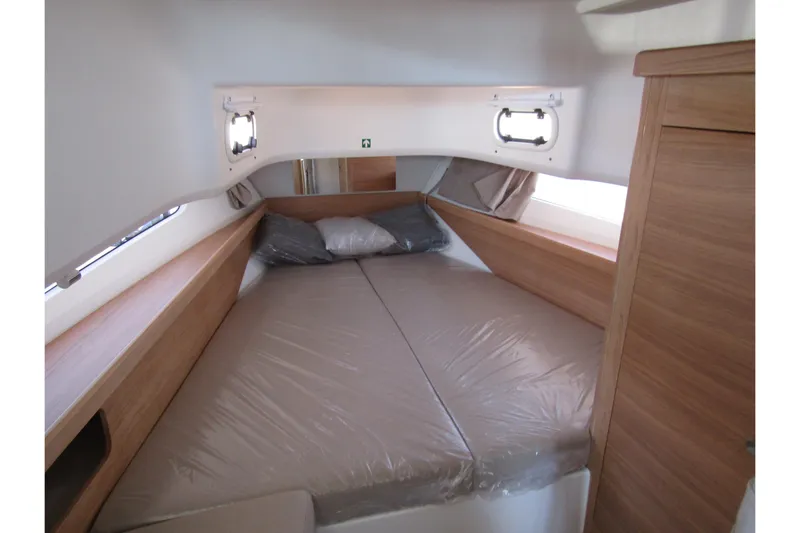  Yacht Photos Pics Interior cabin of 2025 Nimbus Commuter 11, featuring a cozy bed and wooden accents.