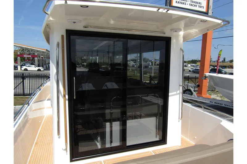  Yacht Photos Pics 2025 Nimbus Commuter 11 boat with sleek glass door and modern design.