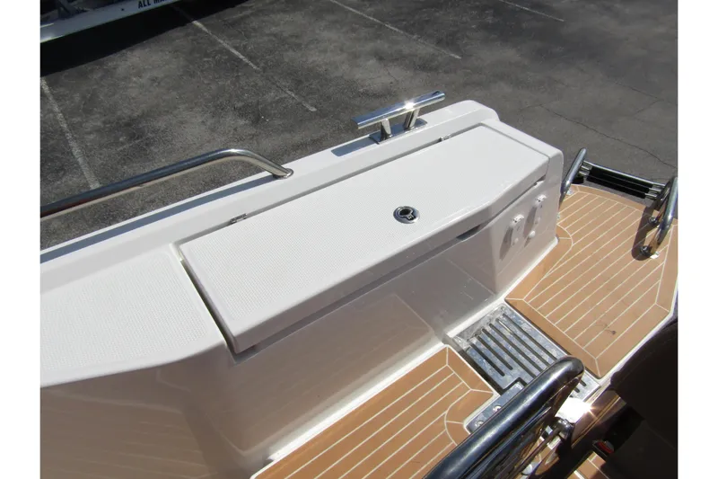  Yacht Photos Pics 2025 Nimbus Commuter 11 boat deck with storage compartment and railing.